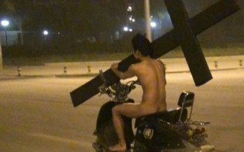 Naked Man Rides Down West State Street On Scooter With Giant Cross